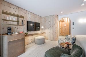 pokój z łóżkiem, telewizorem i kanapą w obiekcie Relais & Châteaux Chasa Montana w mieście Samnaun