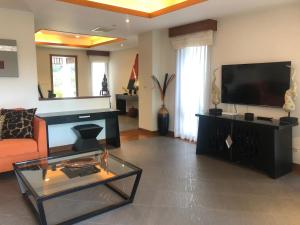 a living room with a flat screen tv and a couch at Pool Villa Phuket 2 bedroom in Layan Beach