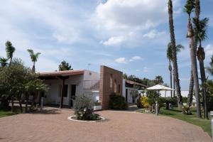 a house with palm trees and a brick driveway at Villetta Del Salento Exclusive B&B in Gallipoli