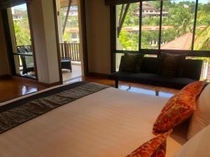 a bedroom with a bed and a large window at Pool Villa Phuket 2 bedroom in Layan Beach