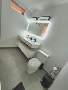 a bathroom with a white toilet and a sink at Hillside Village Retreat in Rio Grande