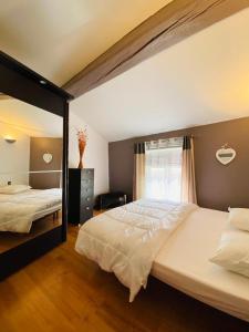 ein großes Schlafzimmer mit 2 Betten und einem Fenster in der Unterkunft Saint Estève maison authentique et charme assuré in Saint-Estève