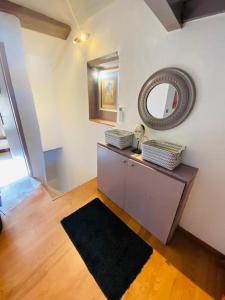 a room with a mirror and a table with a rug at Saint Estève maison authentique et charme assuré in Saint-Estève
