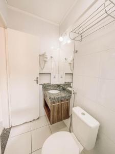 une salle de bains blanche avec toilettes et lavabo dans l'établissement Caldas Novas, Hotel Lacqua diRoma 1,2,3,4 e 5, à Caldas Novas