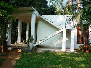 una casa blanca con una escalera en un patio en Twinkle Tangalle Villa en Tangalle