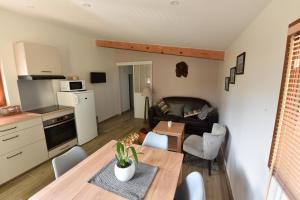 kuchnia i salon ze stołem i kanapą w obiekcie Gîte du Gué Maraud w mieście Magny-Lormes