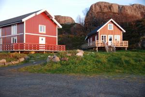 a red house and a house with a balcony at Sandvika Camping in Kabelvåg
