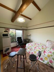 a bedroom with a bed and two chairs and a table at Kyoto Wakouan Retro Stay in Kinugasa