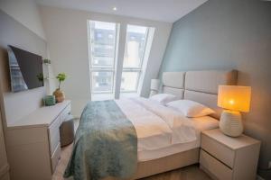 Penthouse Royal, Luxurious and cozy with Sauna في كادزاند: غرفة نوم مع سرير ومكتب مع مصباح