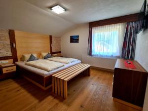 1 dormitorio con cama y banco. en Luttinger-Hohenegg en Ehrwald