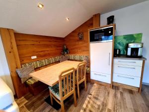 Il comprend une cuisine équipée d'une table en bois et d'un réfrigérateur. dans l'établissement Luttinger-Hohenegg, à Ehrwald