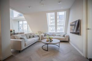 a living room with a couch and a table at Penthouse Royal, Luxurious and cozy with Sauna in Cadzand