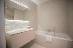 a white bathroom with a tub and a sink at Penthouse Royal, Luxurious and cozy with Sauna in Cadzand +65 photos