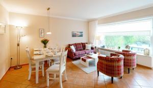 a living room with a table and a couch at Haushälfte Stranddiestel in Wenningstedt