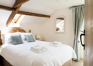 Un dormitorio con una cama blanca con toallas. en Neuadd B&B Suites, en Crickhowell