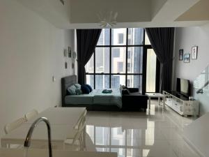 - un salon avec un lit et une grande fenêtre dans l'établissement EmEx Luxurious stay T2U29, à Kuala Lumpur