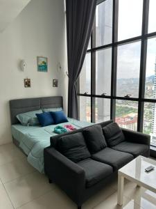 - un lit et un canapé dans une chambre avec fenêtre dans l'établissement EmEx Luxurious stay T2U29, à Kuala Lumpur