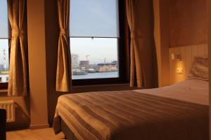een slaapkamer met een bed en een raam bij Hotel Rubens in Oostende
