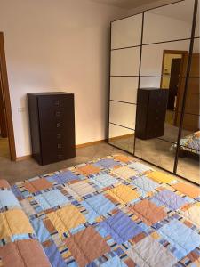 1 dormitorio con edredón en el suelo y espejo en La Casa del Ciarlatano, en Cerreto di Spoleto