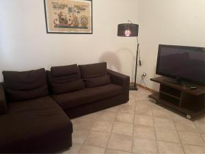 sala de estar con sofá y TV de pantalla plana en La Casa del Ciarlatano, en Cerreto di Spoleto