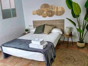 a bedroom with a bed with towels on it at Casa Indalo - Resort Macenas Mojacar in Mojácar