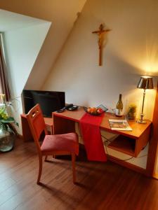 a room with a desk with a cross on the wall at Gästehaus Schweiklberg in Vilshofen an der Donau