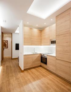 kuchnia z drewnianymi szafkami i zlewem w obiekcie Plaza España V calle San Bernardino 6BR 6BH w Madrycie