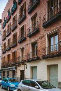 a red brick building with cars parked in front of it at San Bernardino 15 in Madrid