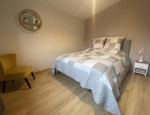 sypialnia z łóżkiem, krzesłem i lustrem w obiekcie Gîte du Gué Maraud w mieście Magny-Lormes