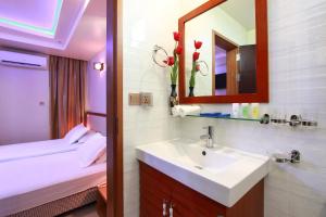 a bathroom with a sink and a bed and a mirror at Season Holidays at Hulhumale with Transfer in Hulhumale