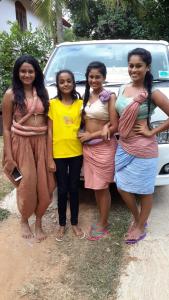 Un groupe de filles debout devant une voiture dans l'établissement Hotel Chanaya, à Ambanpola