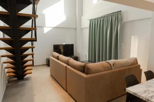 sala de estar con sofá y TV en Athens Heart Luxury Apartment, en Atenas
