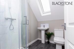 uma casa de banho com um chuveiro, um WC e um lavatório. em Champagne House - 4 Bed Property plus 2 sofa beds by BPNE em Darlington