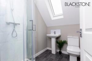 a bathroom with a shower and a toilet and a sink at Champagne House - 4 Bed Property plus 2 sofa beds by BPNE in Darlington