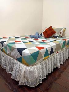 a large bed with a colorful blanket on it at Balai Vivencio Hostel in Puerto Princesa City