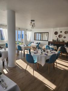 a restaurant with white tables and blue chairs at Auberge la musardière in Chagny