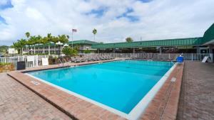 a large swimming pool with chairs and a building at Waterfront Room, Heated Pool, Tiki Bar & Grill in Sarasota