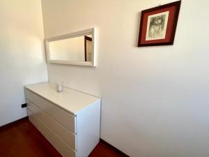 a white dresser with a mirror on a wall at Todeschini 27 in Brembate