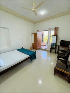 1 dormitorio con cama, silla y piano en Hiddenvalley Stays - Nethra, en Madikeri