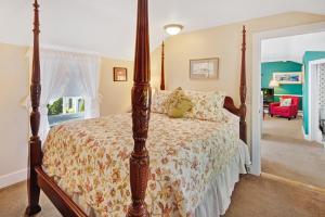 um quarto com uma cama de dossel num quarto em The Lightkeeper’s Inn em Edgartown