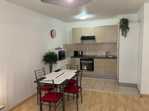 een keuken met een tafel en stoelen in een kamer bij Le gîte de Marc - Parking privé gratuit + terrasse in Colmar
