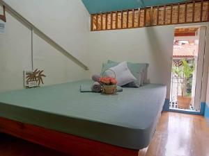 ein Schlafzimmer mit einem Bett mit einem Blumenkorb darauf in der Unterkunft Balai Vivencio Hostel in Puerto Princesa