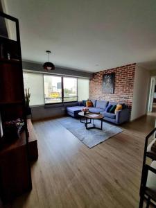 a living room with a couch and a brick wall at ¡Lindo y acogedor apartamento en Barranco! in Lima