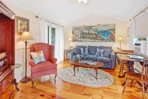 uma sala de estar com um sofá azul e uma mesa em The Lightkeeper’s Inn em Edgartown