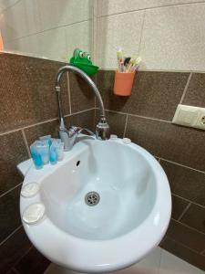 lavabo blanco con grifo en el baño en APARTMENT in TBILISI Koko en Tiflis