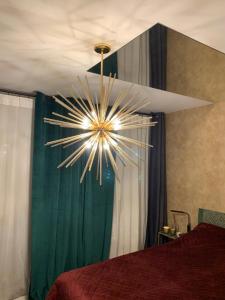 a chandelier hanging from a ceiling in a bedroom at Apartament Gold in Złotoryja