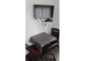 un tavolo in una stanza con TV a parete di Vila da Praia a Boicucanga