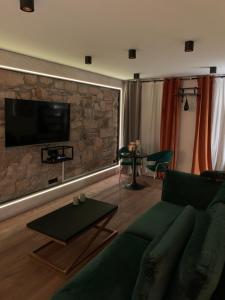 a living room with a couch and a stone wall at Apartament Gold in Złotoryja