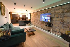 a living room with a couch and a stone wall at Apartament Gold in Złotoryja