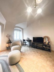 a living room with two chairs and a flat screen tv at Apartment im Wein- und Freizeitidyll Klöch in Klöch